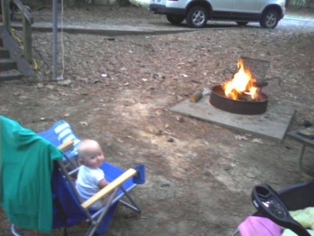 Baby on Lounge Chair in front of bonfire
